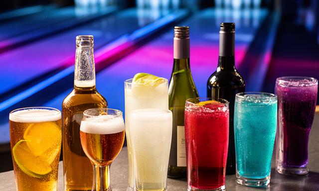 Gläser mit Bier, Wein und Softdrinks auf einer Bar neben einer Bowlingbahn